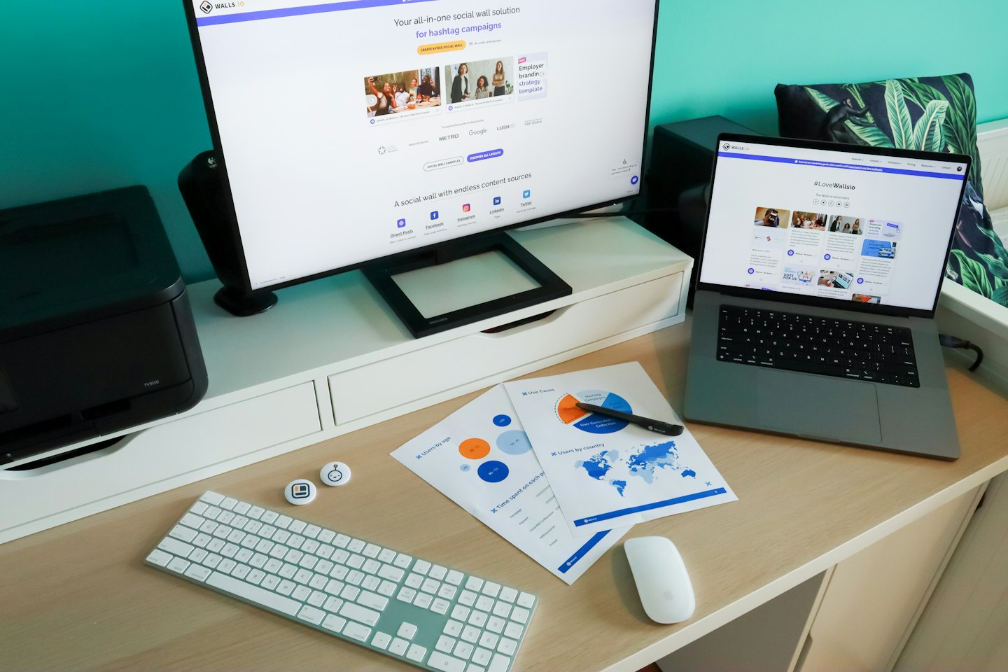 Escritorio de oficina en casa con monitores, informes e impresora.